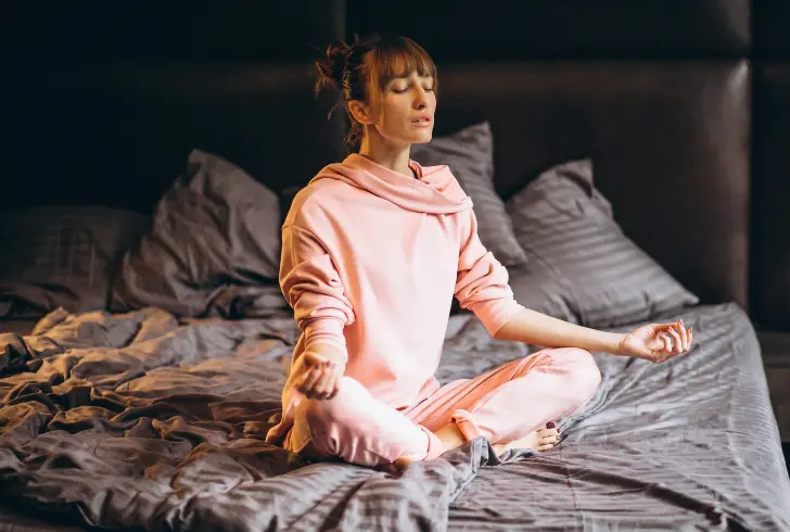 Woman meditating before bedtime for relaxation